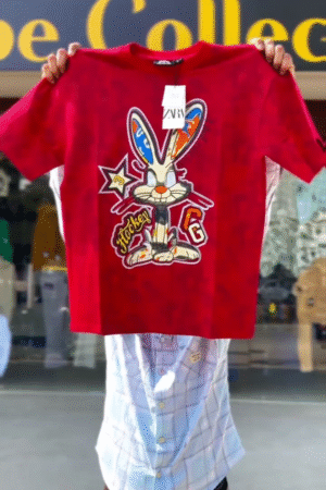 Vibrant Red Oversized Cartoon Bunny Graphic Streetwear T-Shirt with Multicolor Ear Detail and Bold Letter Patch Design